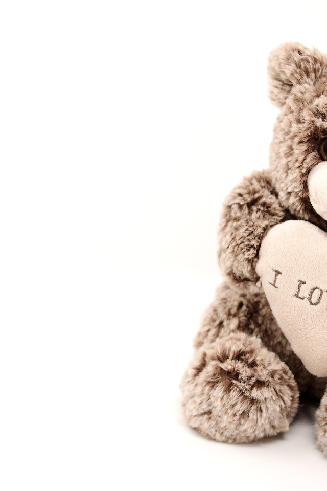 Меховая игрушка медвежонок с сердцем на белом фоне