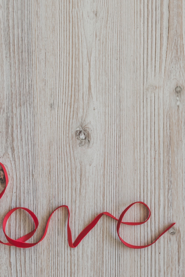 Коробка с подарком  и надпись любовь красной лентой на деревянном фоне