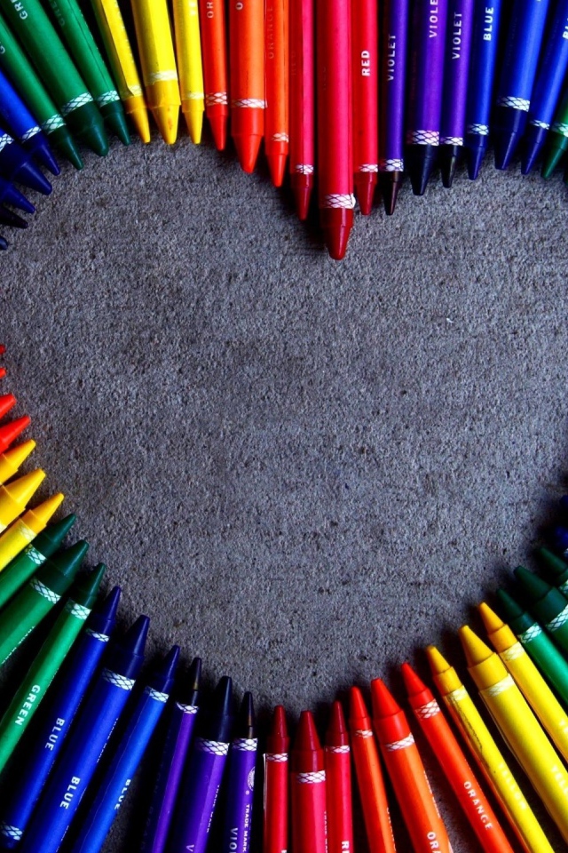 Сердце  из разноцветных карандаш на сером фоне 