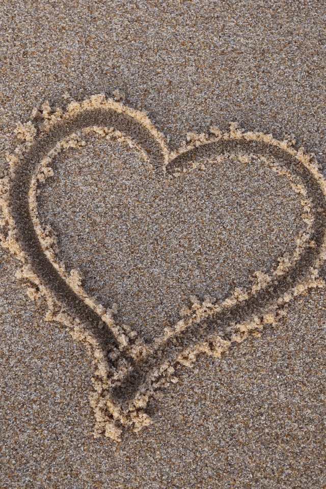 Сердце нарисовано на мокром песке 