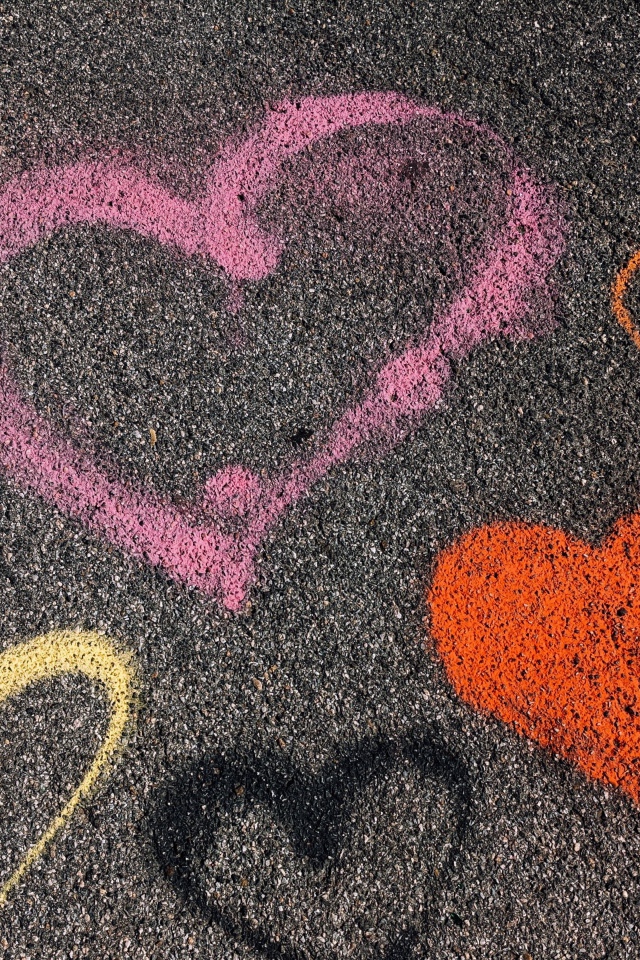 Hearts with multicolored chalk on the asphalt