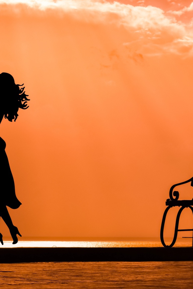 Поцелуй влюбленной пары на закате у лавки