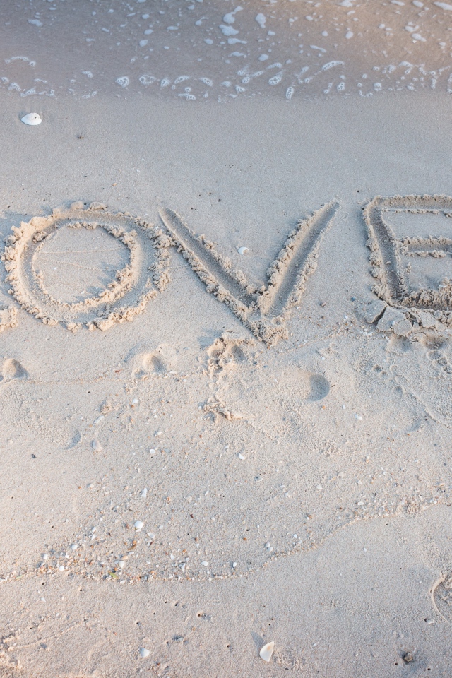 Надпись Любовь на мокром песке у моря