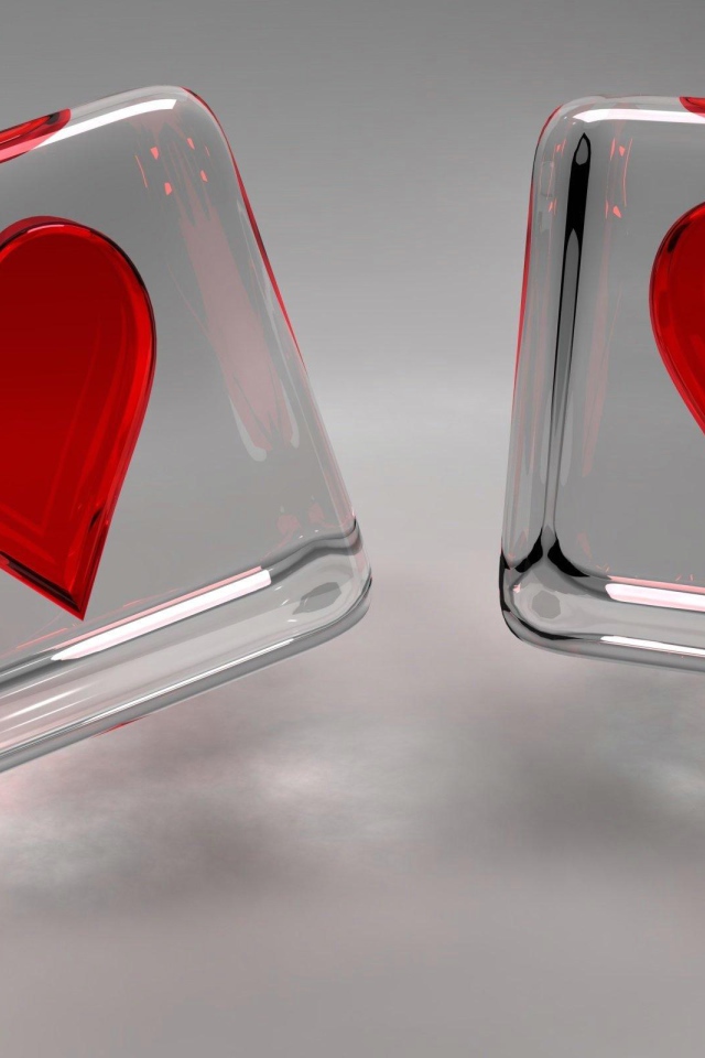 Два стеклянных кубика с сердечками на сером фоне