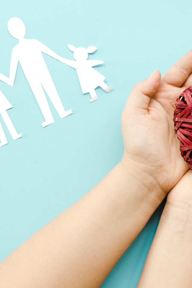 Плетеное сердце в руках на голубом фоне