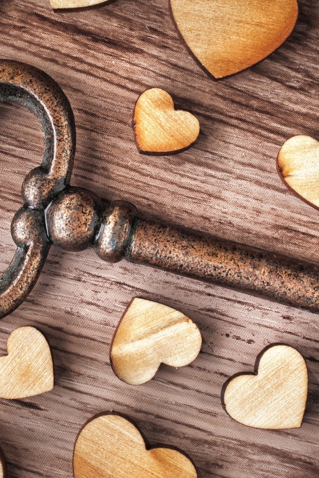 Деревянные сердечки на столе с ключом 