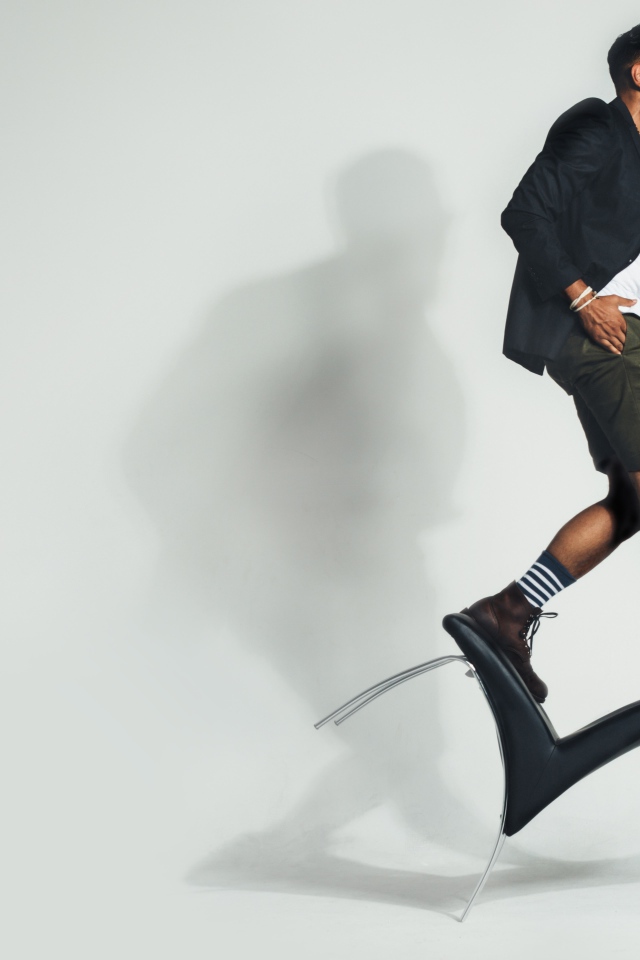 Мужчина балансирует на черном кресле