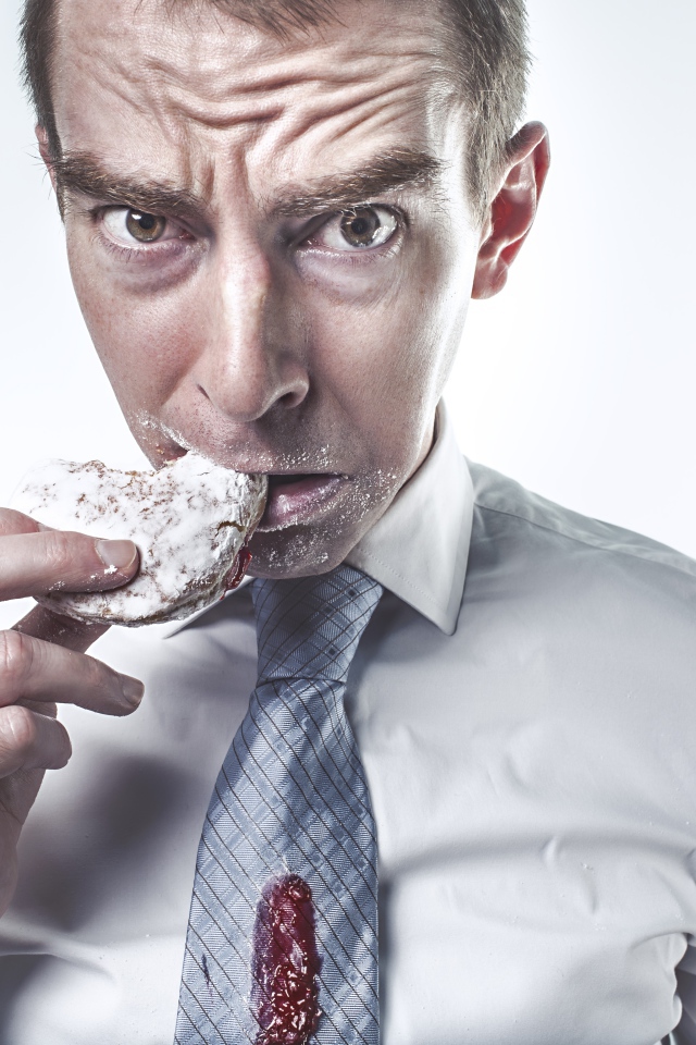Мужчина в рубашке грызет пряник