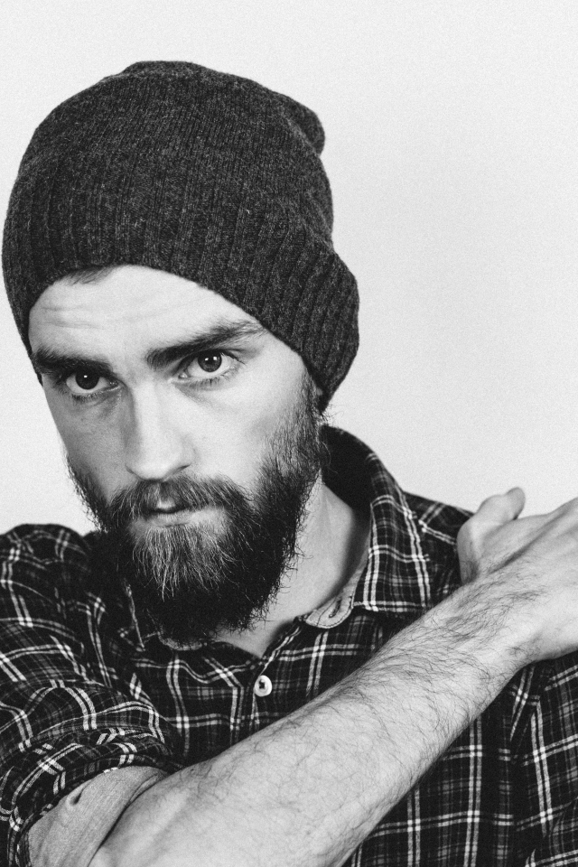 Бородатый мужчина в шапке на белом фоне 