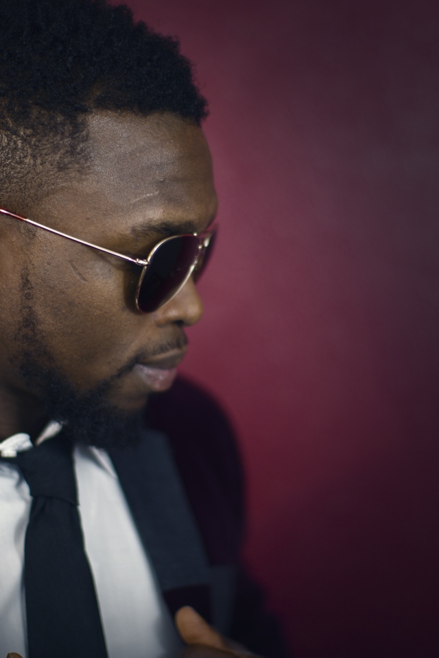 Темнокожий мужчина в костюме и очках 