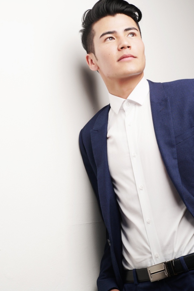 Мужчина модель в костюме у белой стены