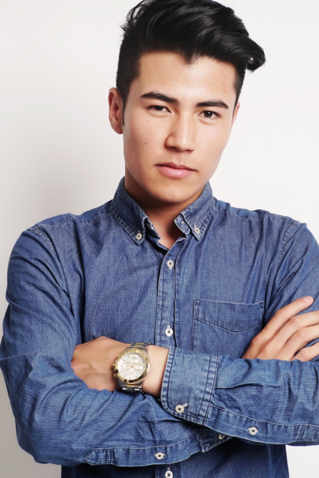 Мужчина в синей рубашке на сером фоне 