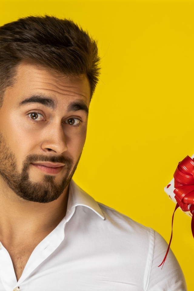 Мужчина с подарком на желтом фоне 