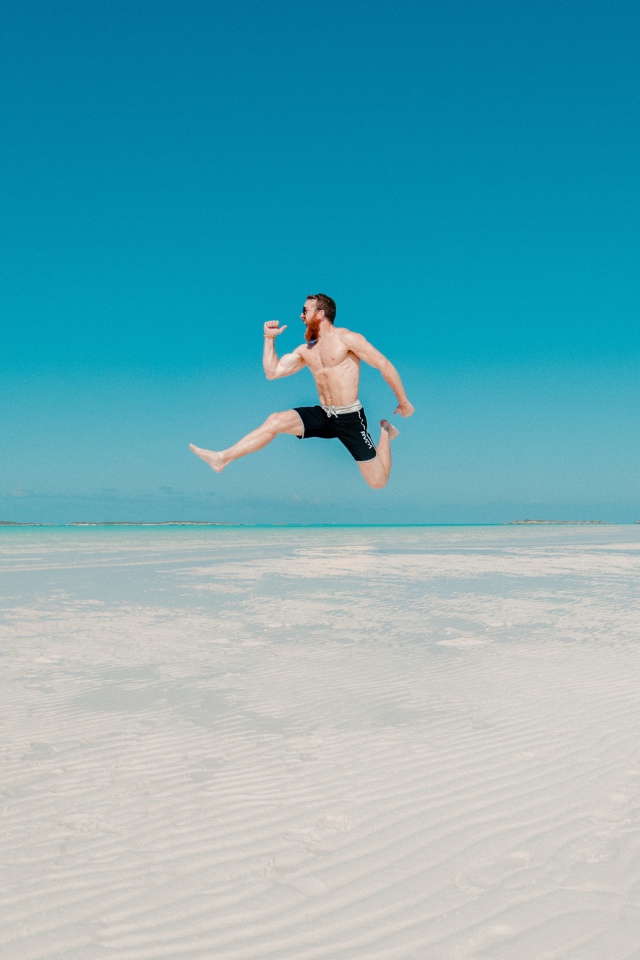 Довольный мужчина прыгает в воде на голубом фоне 