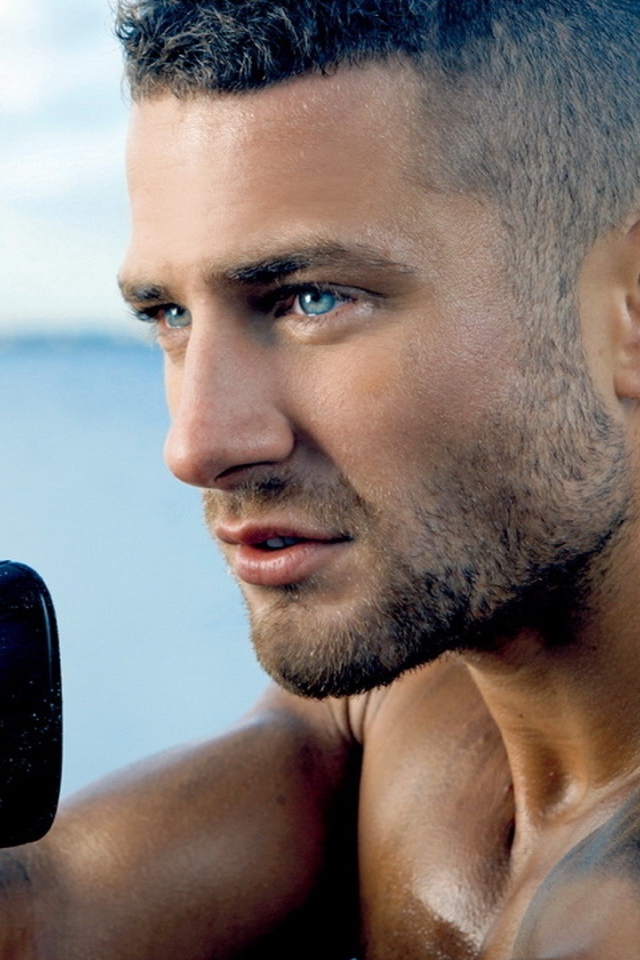 Сильный голубоглазый мужчина с винтовкой в руках 