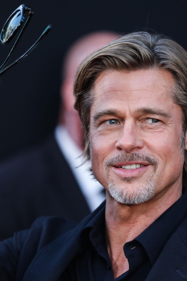 Актер Брэд Питт с очками в руке