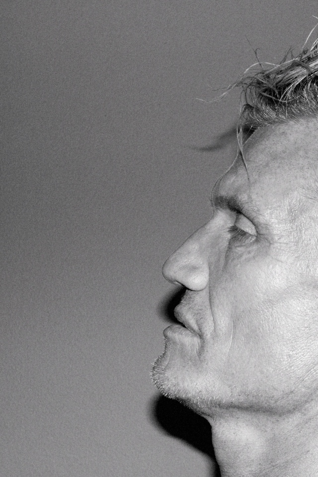 Лицо актера Дольфа Лундгрена боком на сером фоне