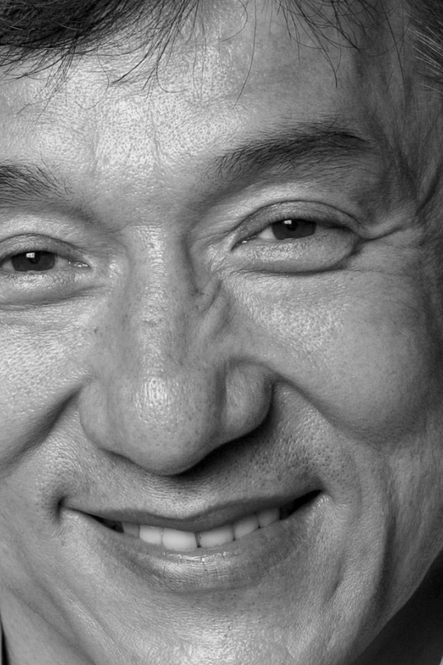 Лицо актера Джеки Чана на черном фоне