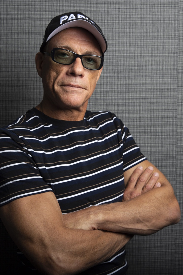 Популярный актер Жан-Клод Ван Дамм в кепке у стены