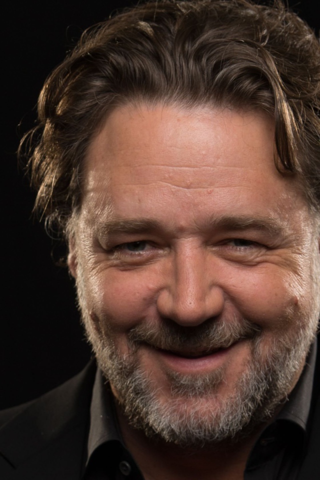 Улыбающийся Рассел Кроу на черном фоне