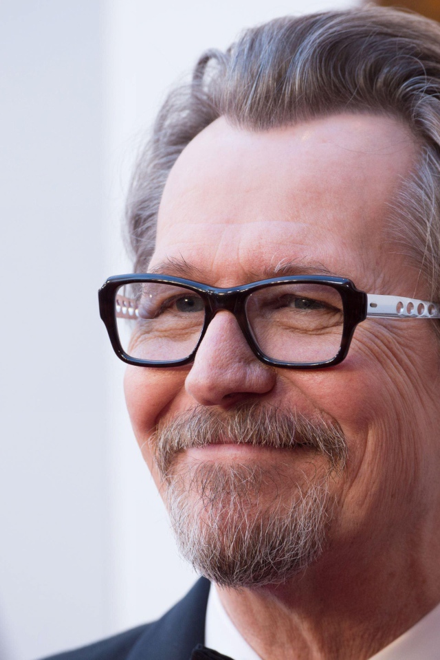 Улыбающийся мужчина, актер Гари Олдман в очках