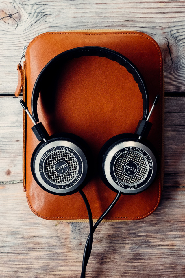 Наушники и плеер в чехле на деревянном столе