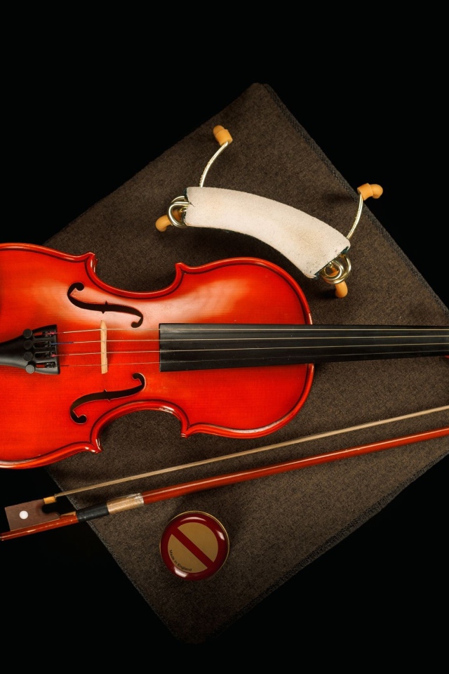 Красная скрипка со смычком на черном фоне