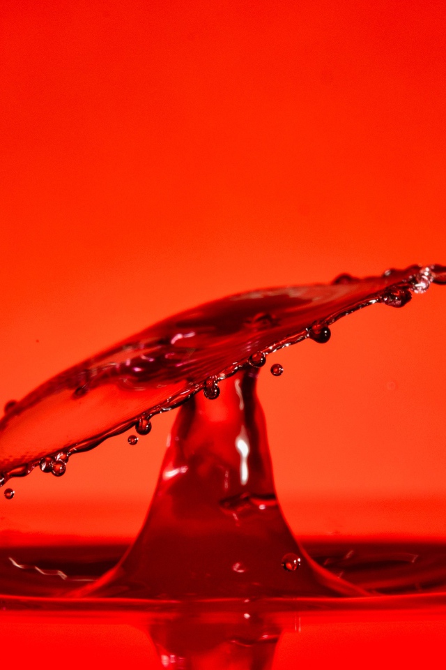 Брызги воды на красном фоне