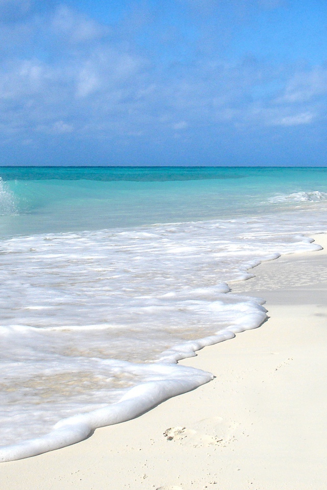Чистый белый песок на пляже с голубой водой