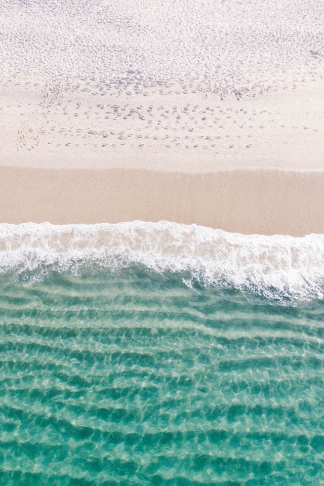 Белый морской песок на берегу у голубой воды