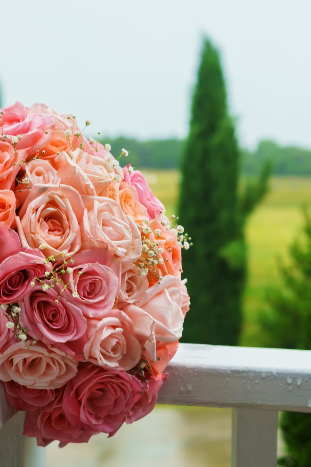 Красивый свадебный букет розовых роз на белых перилах