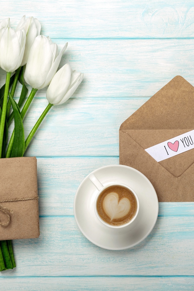 Букет белых тюльпанов на столе с подарком и чашкой кофе