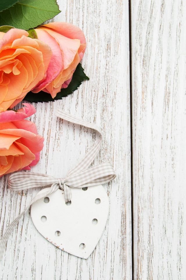 Три оранжевых цветка розы на сером столе