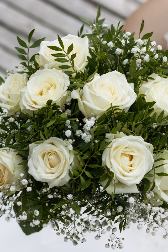 Свадебный букет белых роз в руке у невесты