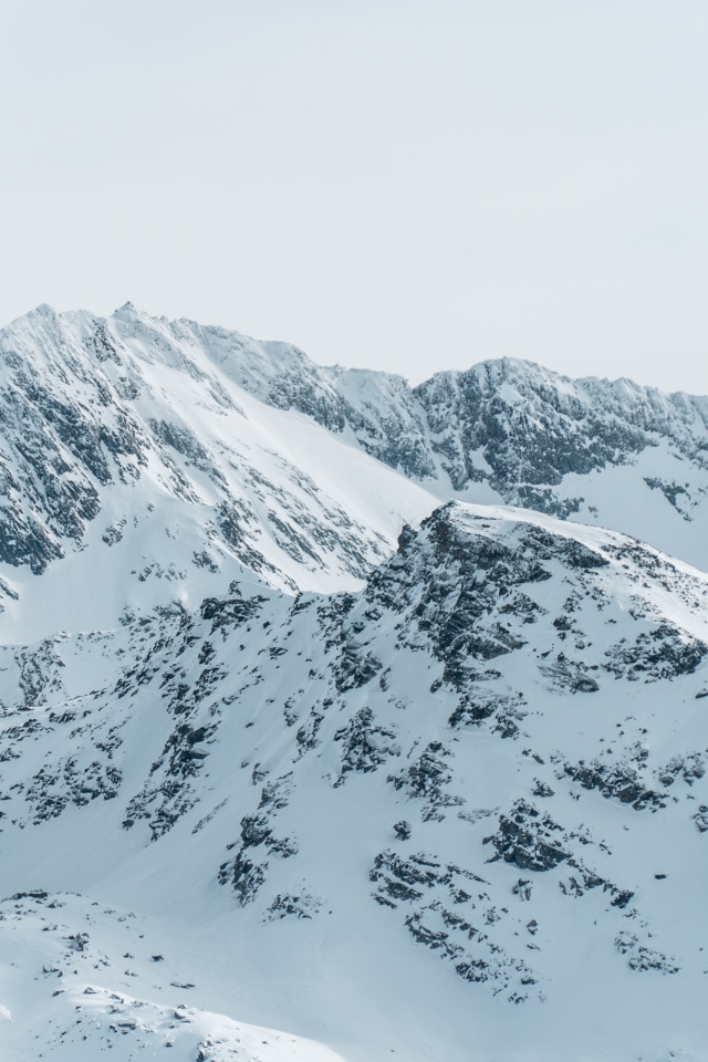 Заснеженная гора под серым небом 