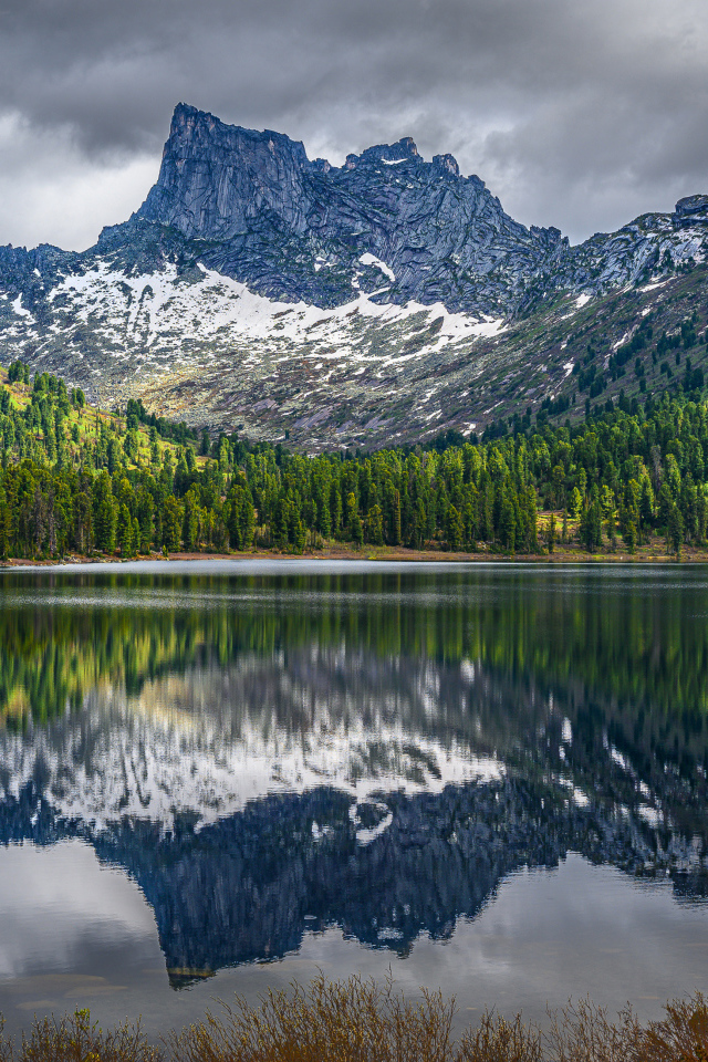 Красивая гора под грозовым небом отражается в озере 