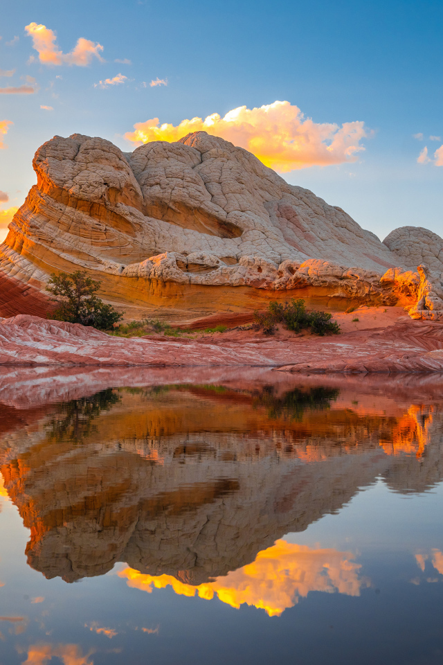 Красивая необычная гора у воды под голубым небом
