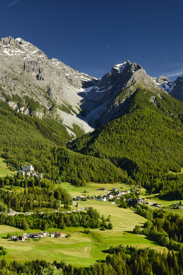 Высокие швейцарские Альпы покрыты зеленью под голубым небом 