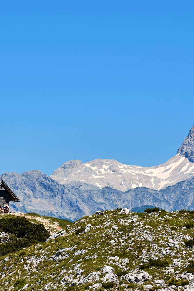 Дом на вершине горы под голубым небом
