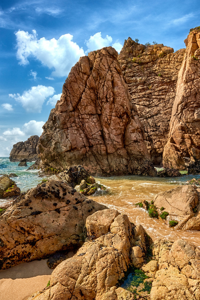 Большие каменные возвышенности в море под голубым небом 