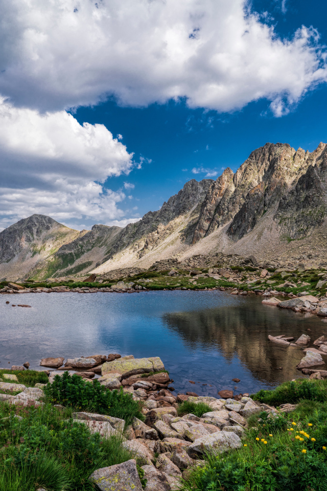 Горы под голубым небом с белыми облаками у озера, Андорра 