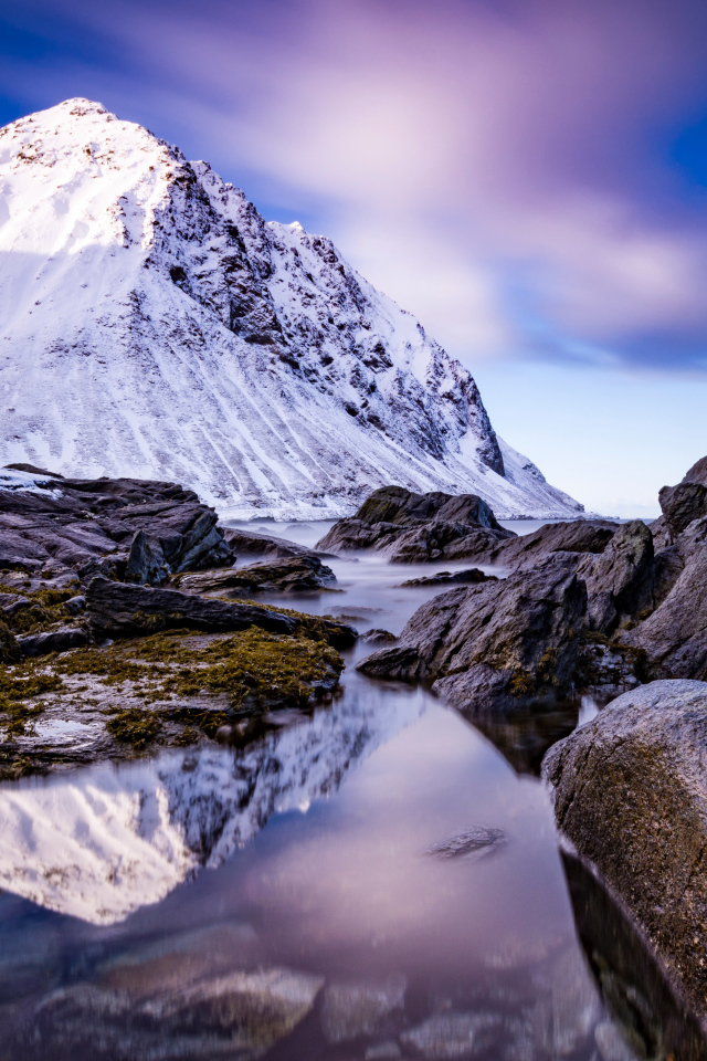 Заснеженные горы у ручья под красивым небом 
