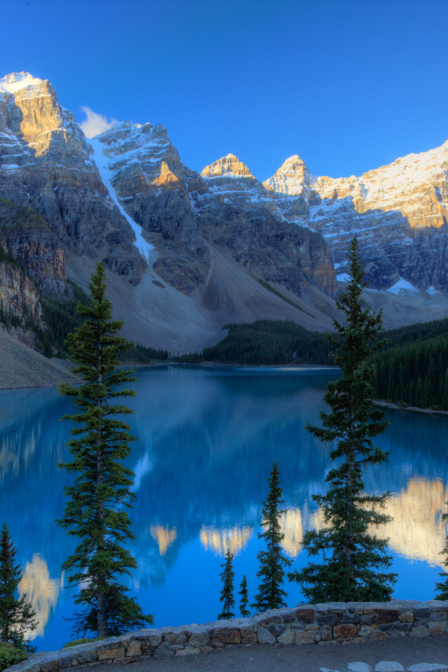 Каменные горы с заснеженными вершинами у озера 