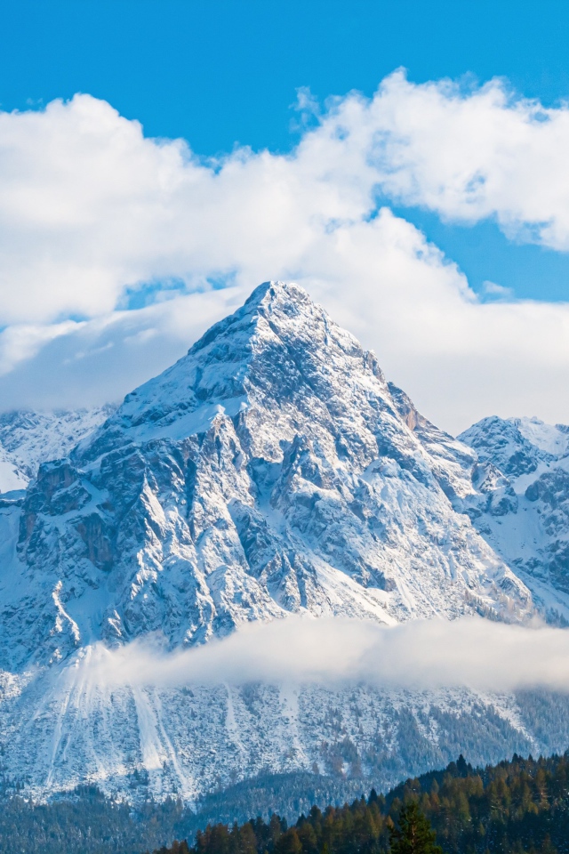 Вершины заснеженных гор под голубым небом 