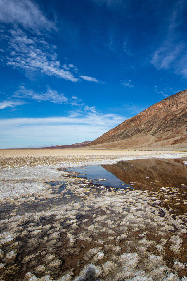 Соленая земля у горы под голубым небом