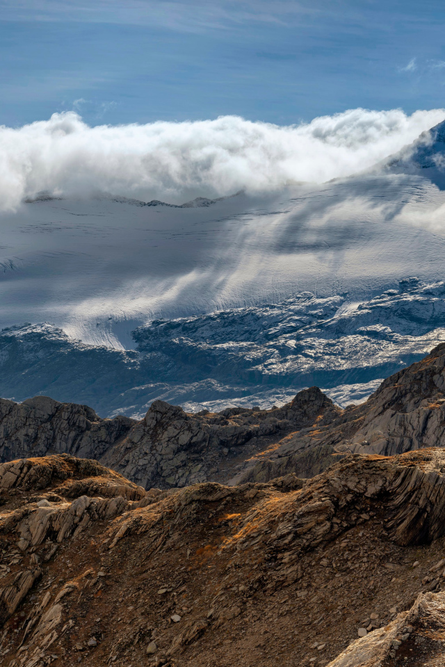 Густые белые облака над заснеженными Альпами