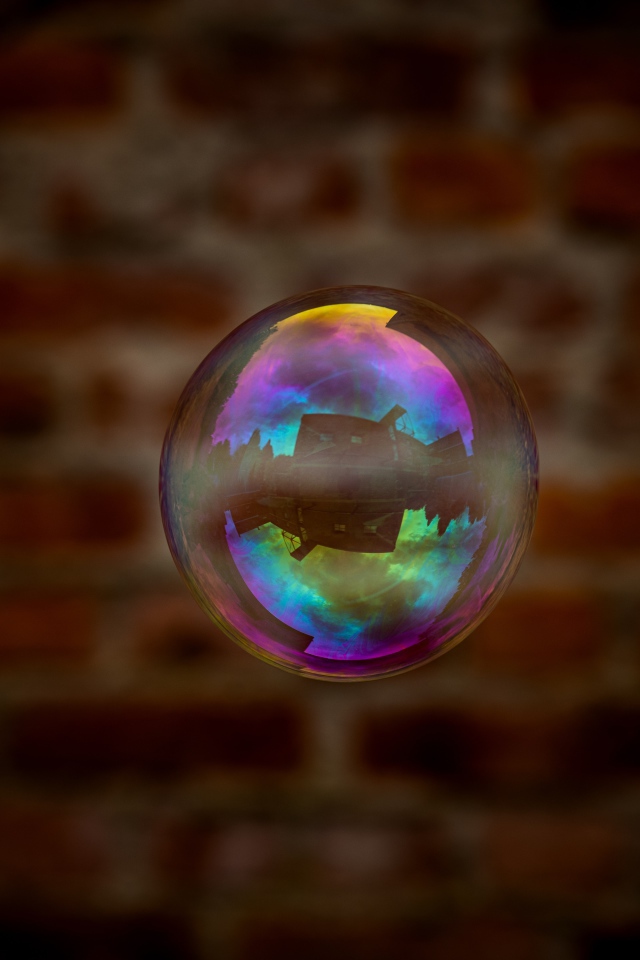 Мыльный пузырь в воздухе на фоне стены