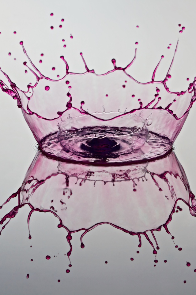 Брызги фиолетовой краски на сером фоне 