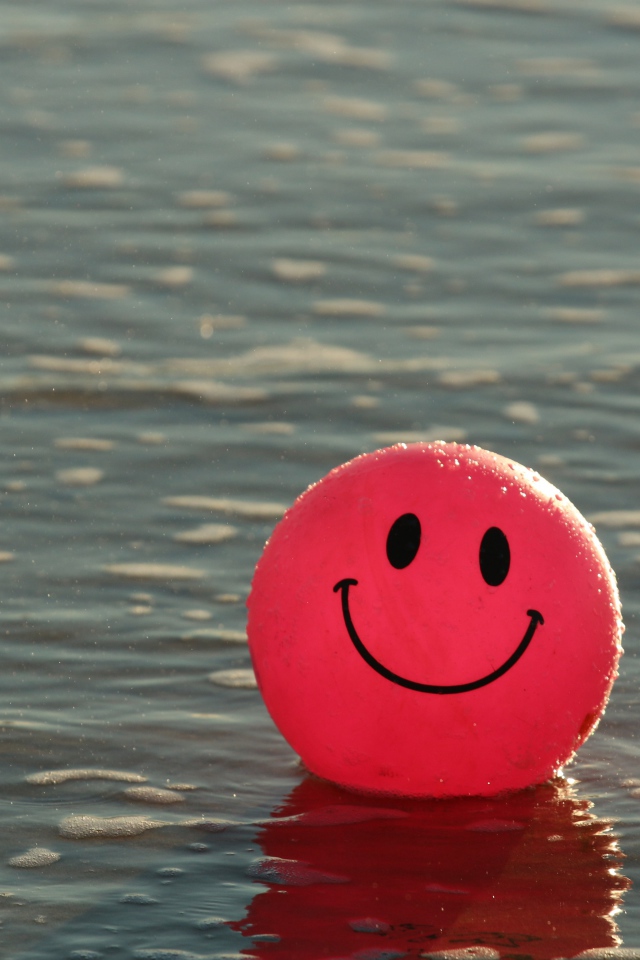 Красный мяч смайлик в воде 
