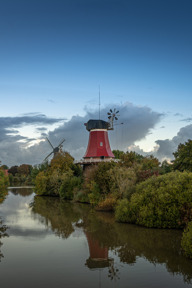 Мельница на берегу реки под красивым небом в сумерках